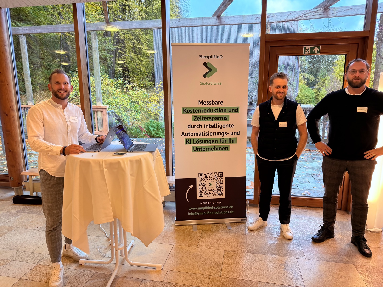 SimplifieD Solutions team with rollup banner at a client event